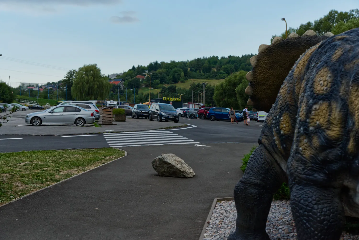 Parkovisko pred Zoo Košice s autami a pohľadom na cestu.