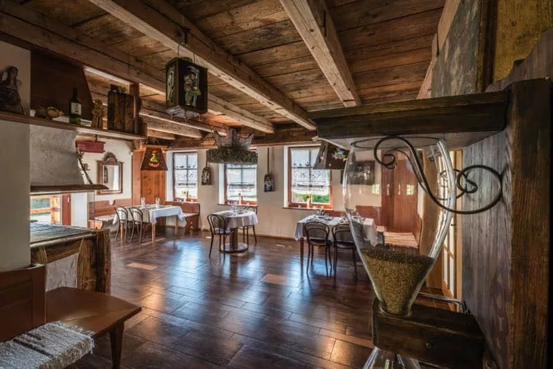 Interier restauracie, stoly a stolicky, drevena podlaha, drevene tramy na strope