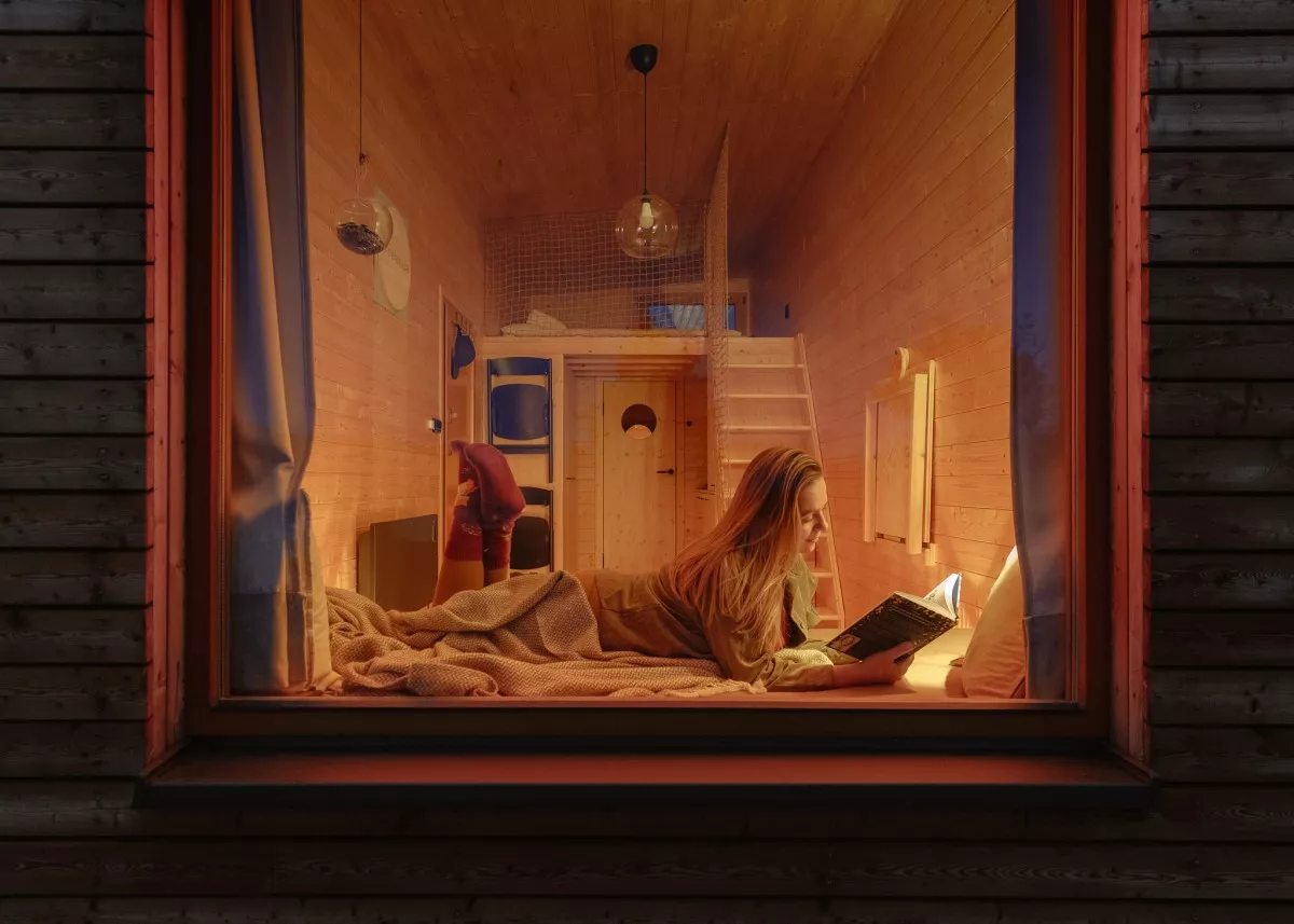 kiva cabins netradicne ubytovanie zena citajuca knihu za oknom